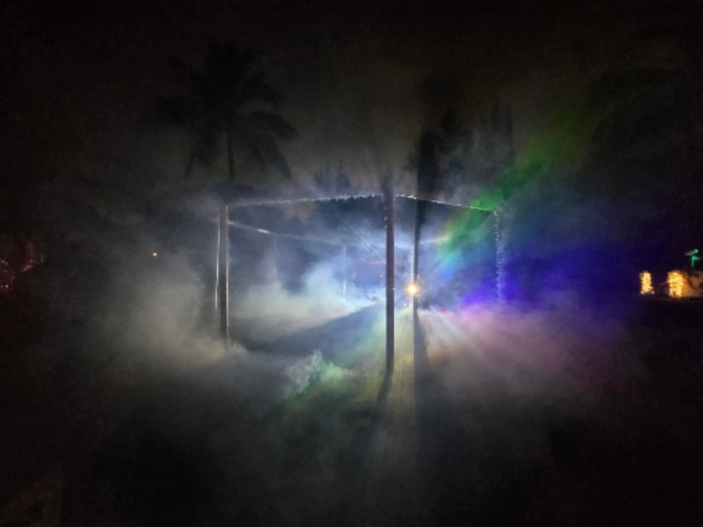 People inside The Octagon, lit by red and violet projections through fog