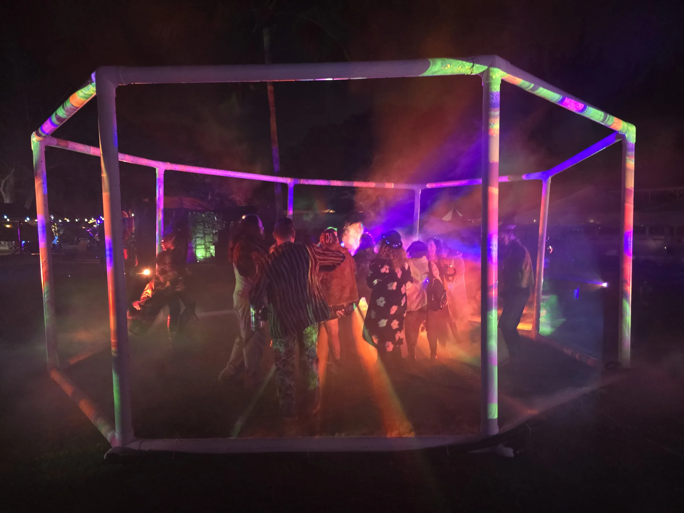 Blue and teal projections converging in the fog-filled octagonal structure