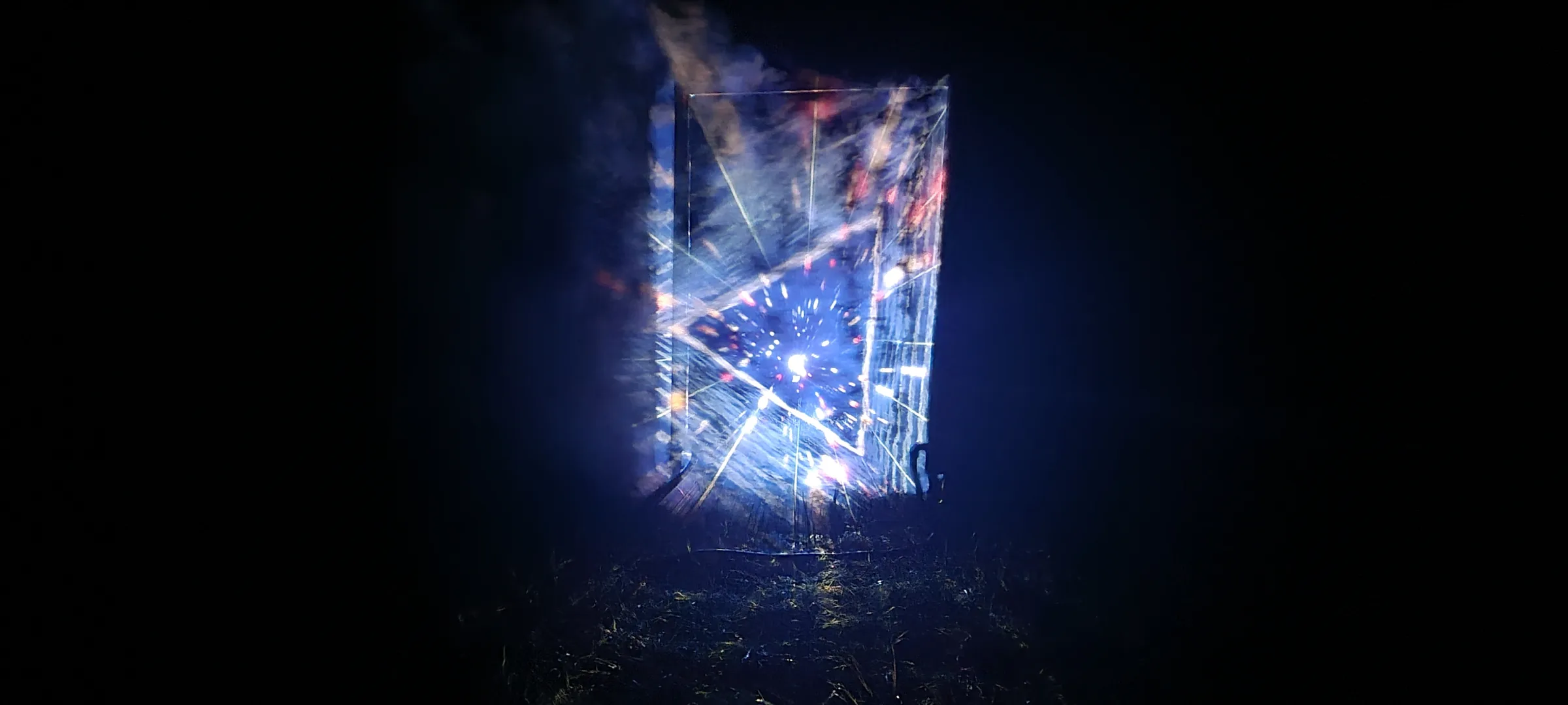 A glowing blue portal stands alone in near-total darkness, radial light rays bursting from its center like a tunnel, grass faintly lit below.